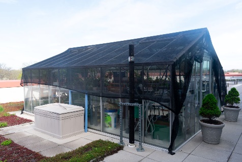 A greenhouse with a black coverDescription automatically generated